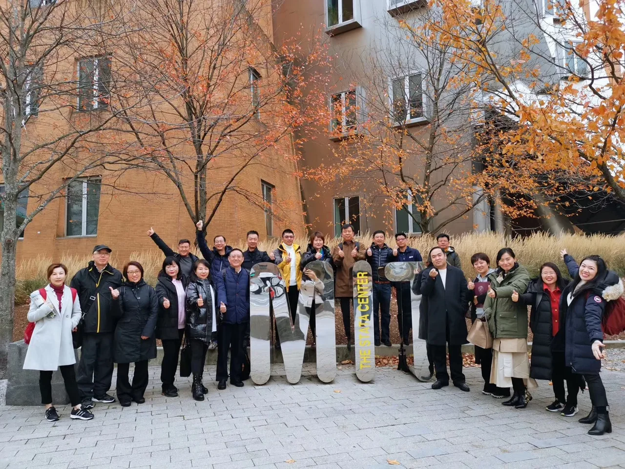 Participants on a past educational visit gathered outside an academic building.